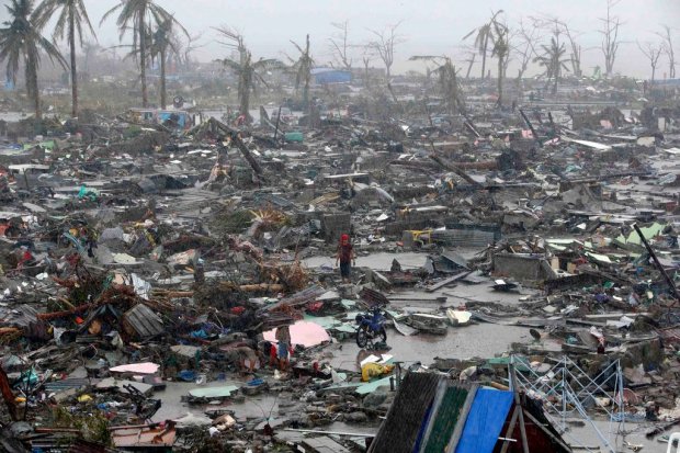 People stood among the ruins of houses destroyed by Typhoon Haiyan in Tacloban, Philippines, a city of about 220,000. (C) NY Times